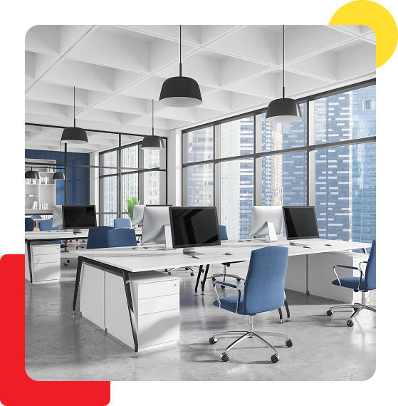 Modern office space with desks, computers, and city views.